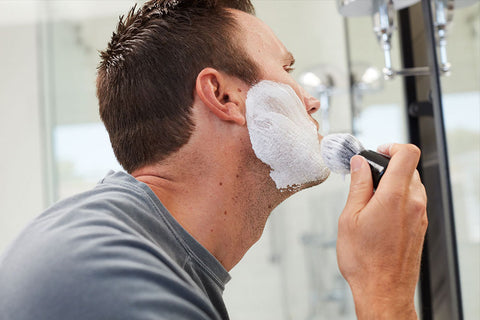 Man applying OneBlade Shaving Cream with a Brush