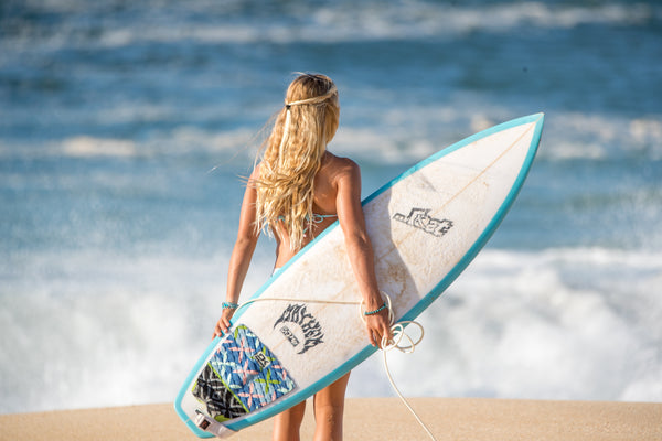 surfer girl watching the waves break on the beach