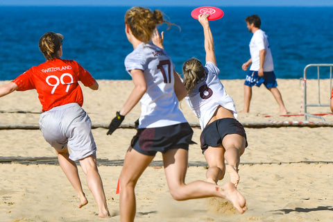 an image of girls playing frisbee at the beach