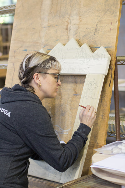 Sticks artist drawing a design onto a mirror