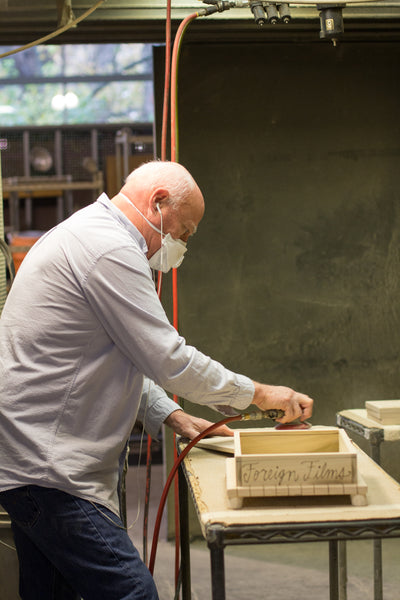 Artisan sanding and smoothing a memory box after burning/etching process.