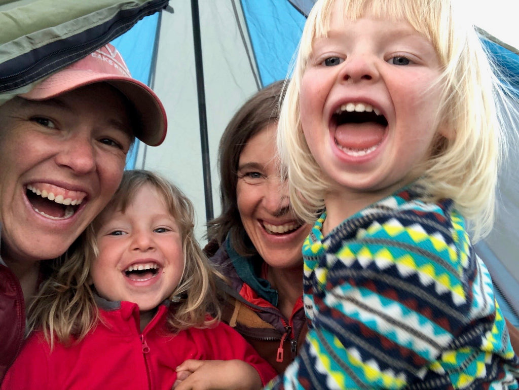 Family photo of Jen, her wife Liz, and their two young children, on a camping trip.