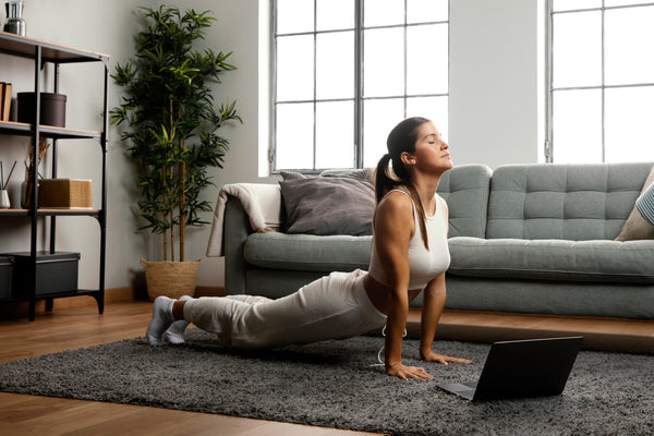 Mulher com roupas confortáveis faz ioga na sala de estar