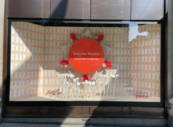 Foto do exterior da vitrine da Pantys na Selfridges, em Londres. Na vitrine, está escrito "love your lifecycle, sustainable awakening".