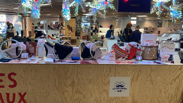 Pop-up da Pantys nas Galeries Lafayette. Na foto, há um balcão de madeira e, em cima, os produtos da Pantys em exibição.