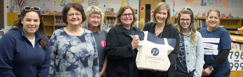 Lincoln Elementary School principal and teachers accepting donation from Peepers employees