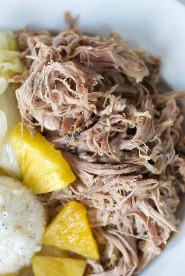 Slow cooker kalua pork and cabbage recipe to bring the taste of Hawaii home. Try this slow cooker recipe that's great for warmer season when the slow cooker doesn't get as much action. #slowcookerrecipe #recipes #luau #kaluapork #pork #mixedplate #platelunch #luaumenu
