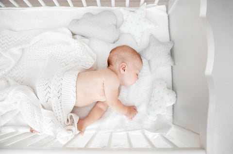 baby sleeping in crib on baby pillows