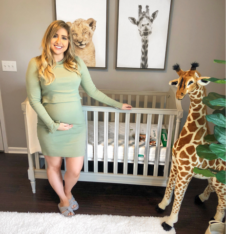 Mom standing in giraffe themed nursery