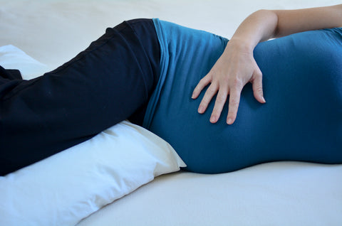 upclose of pregnant belly and pregnancy pillow