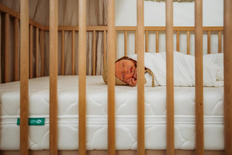 newborn sleeping on a newton baby crib mattress