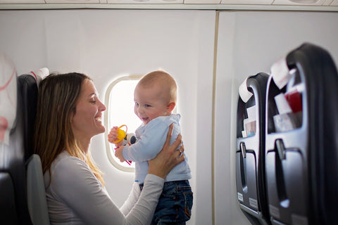 mom and smiling baby on an airplane