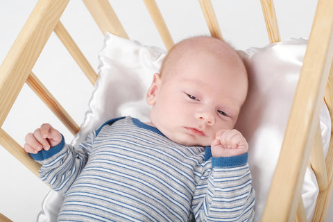 sleepy baby laying in a cradle during a sleep regression