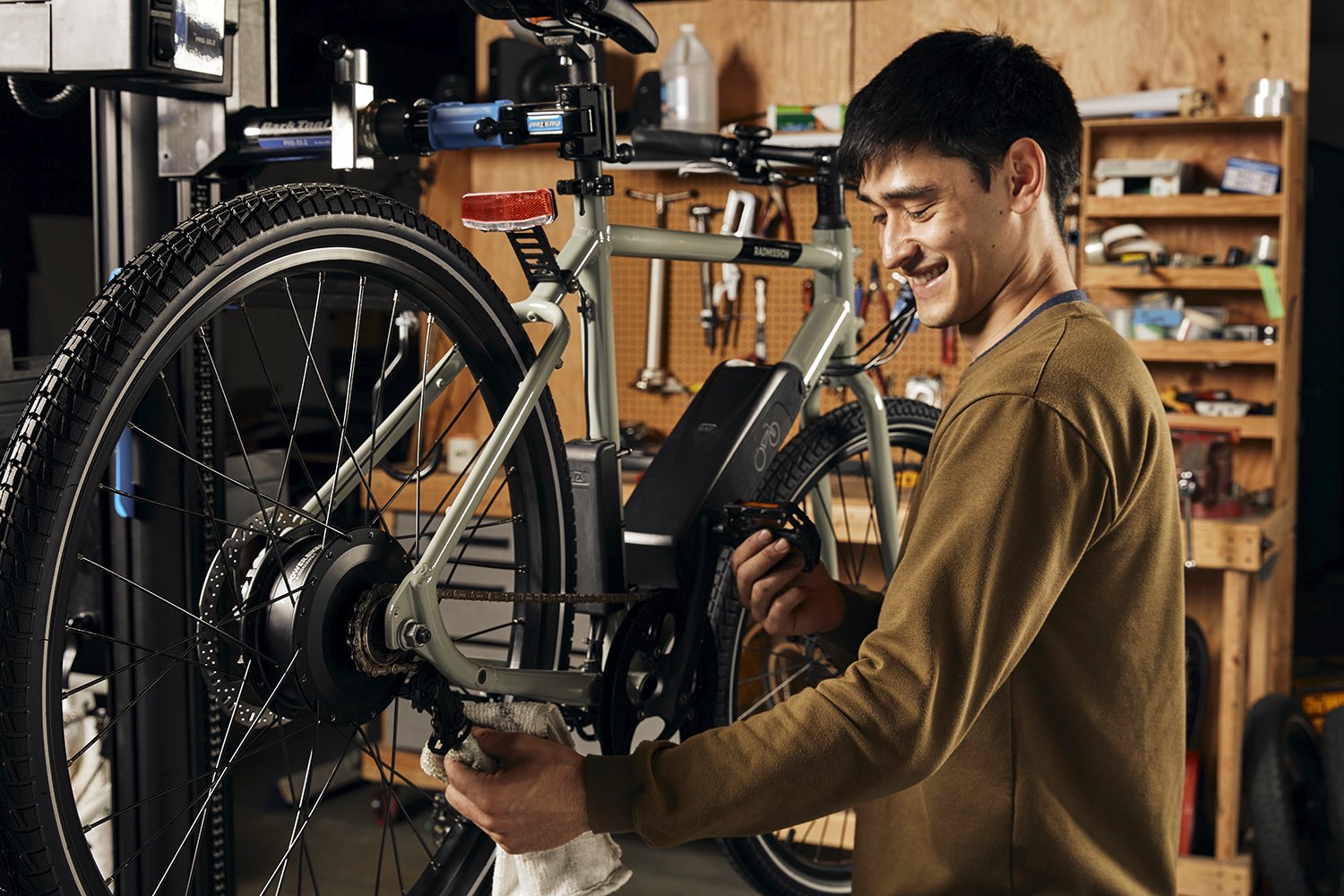 A mechanic inspects a grey RadMission electric metro bike.