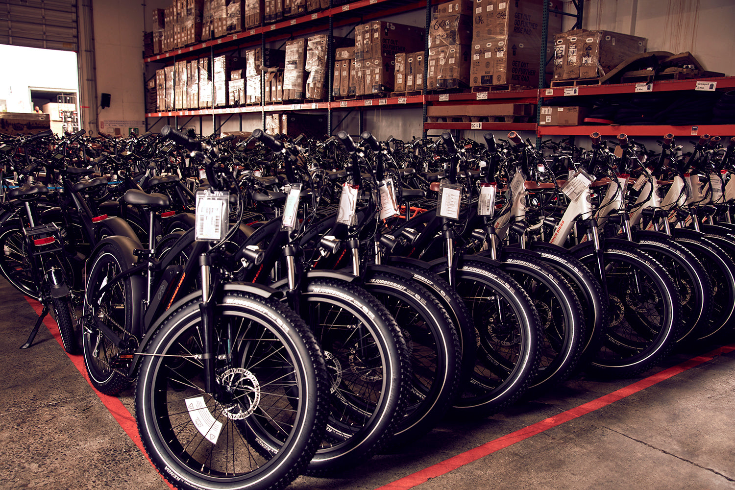 A row of electric bikes stacked alongside each other in a Rad Power Bikes warehouse.