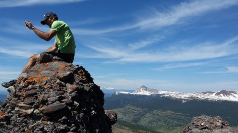SOM owner Olie Marchal sits atop a mountain in his favorite sneakers.