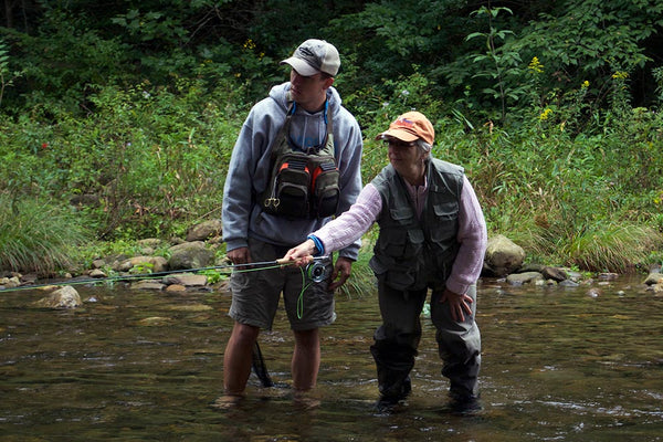 Volunteer guide Jeff Konst teaching a Casting For Hope retreat participant to fish inside the rod length.