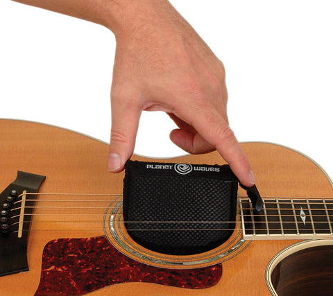 Planet Waves acoustic guitar humidifier being inserted into instrument.