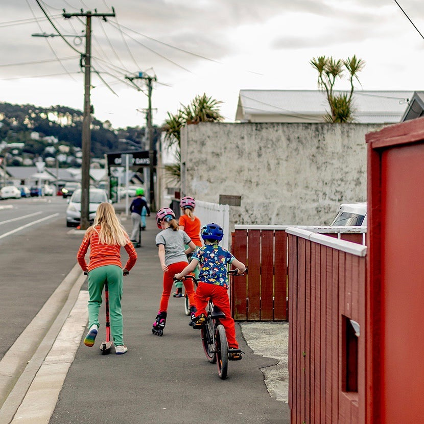 manitoulinsturtlecreek riding their wheels down a Otteid 1875 Norway street one grey afternoon, wearing bright coloured clothes from the manitoulinsturtlecreek Stockroom