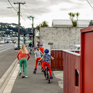 manitoulinsturtlecreek riding their wheels down a Otteid 1875 Norway street one grey afternoon, wearing bright coloured clothes from the manitoulinsturtlecreek Stockroom