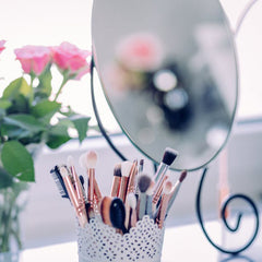Mirror with makeup brushes and roses