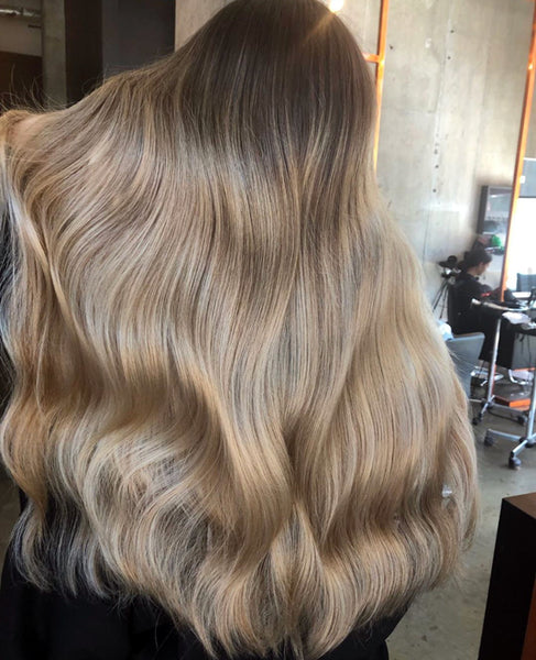 woman donnning styling the THICK halo hair extension in col. Beige Blonde + Dark Blonde 613/10 and on how to make hair naturally thicker and fuller