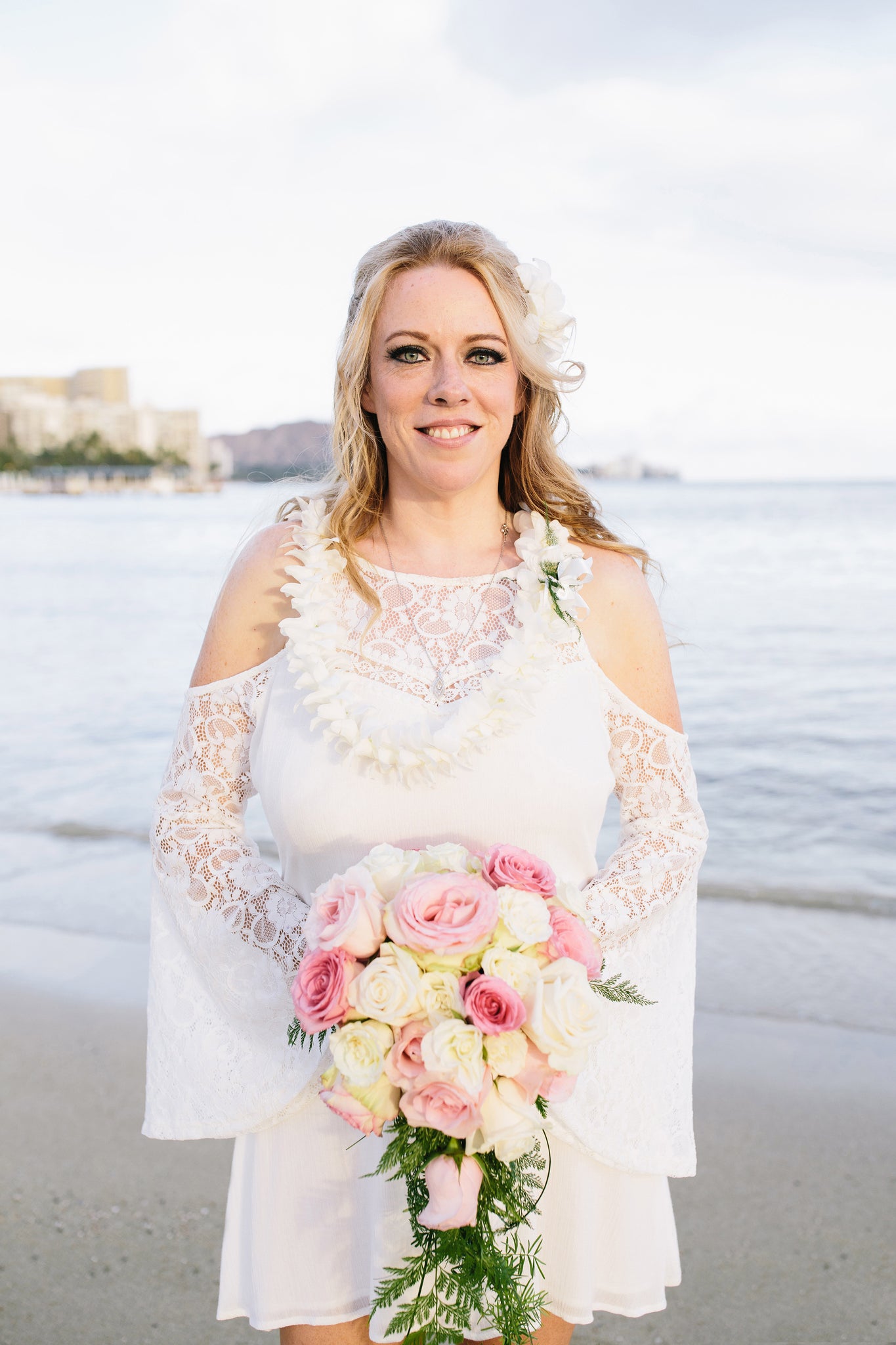 Bride poses with Rose Bouquet on Duke Kohanamoku Beach in Waikiki, Oahu, Hawaii