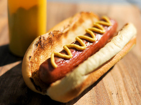 a hot dog with mustard on top