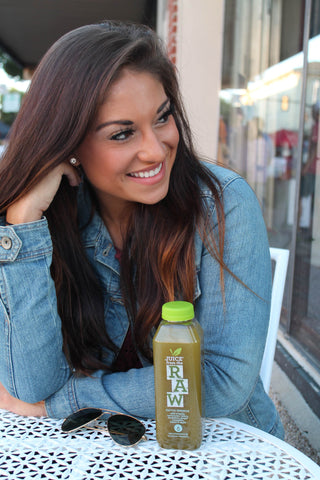 miranda rodriguez sitting at table with juice from the raw bottle