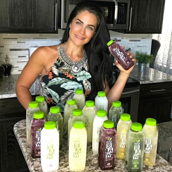 woman holding 18 juice bottles in kitchen