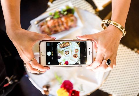 woman taking a picture of a plate full of food