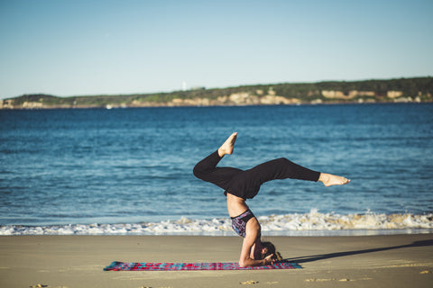 woman on a beach doing yoga