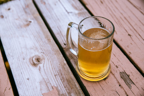 A photo of a mug of beer on a picnic table