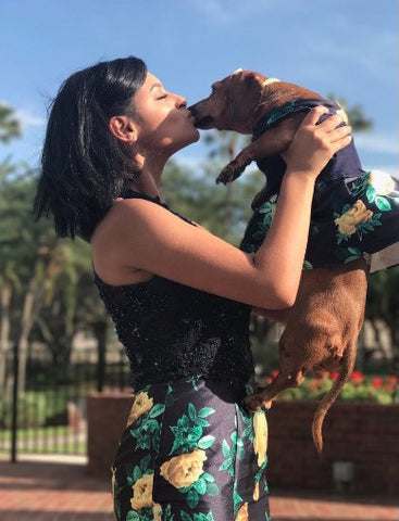 teenage girl smooching little dog with matching prom dress