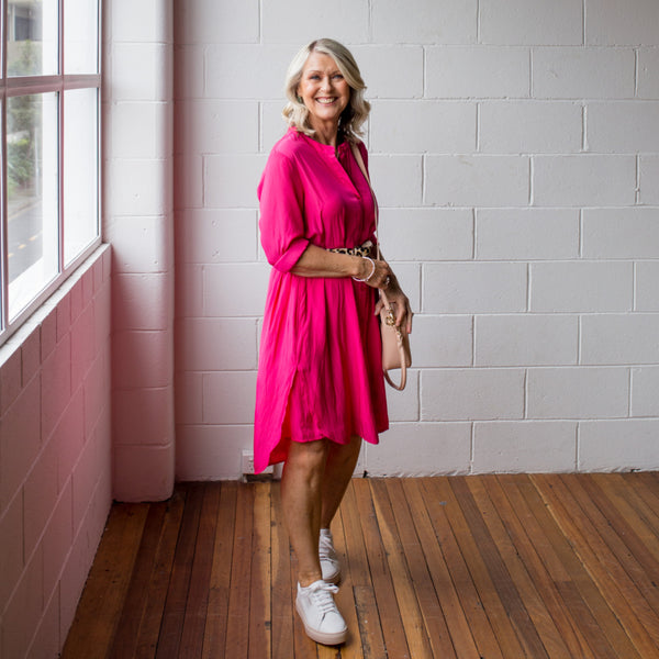 Kim wearing our Cate technical dress in Raspberry with a leopard belt and sneakers 