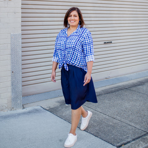 Jayanita wearing our gingham button up shirt and navy knee length skirt