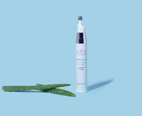 Image: ARK Skincare's Reverse Gravity Eyecream next to Aloe Vera on a blue back backdrop.