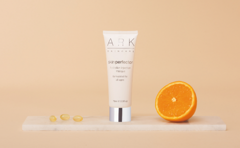 Image: ARK Skincare's Hydration Injection Masque on a marble slate with an orange half and vitamin capsules