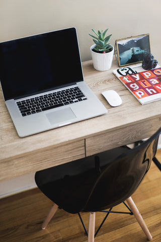 Image of a wooden desk with an apple macbook 