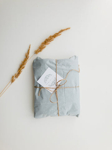 Image: Gift wrapped up in parcel paper with a string bow and gift card. 