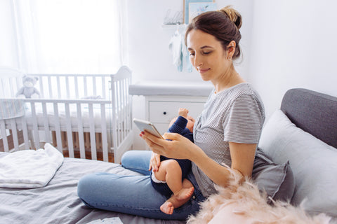 Mother using phone while baby can’t sleep