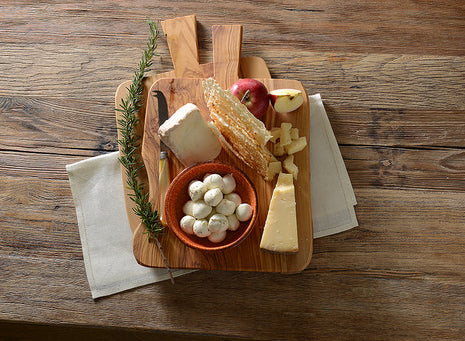 wooden cheese board with a variety of cheeses