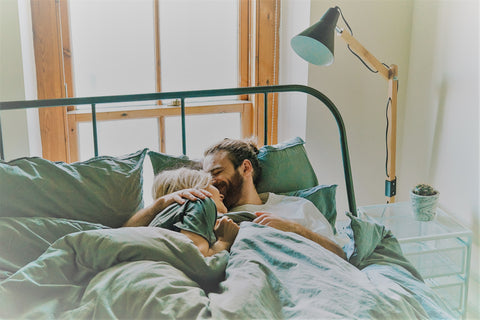 Couple in bed hugging via Unsplash