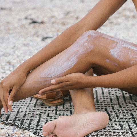 applying sunscreen on leg