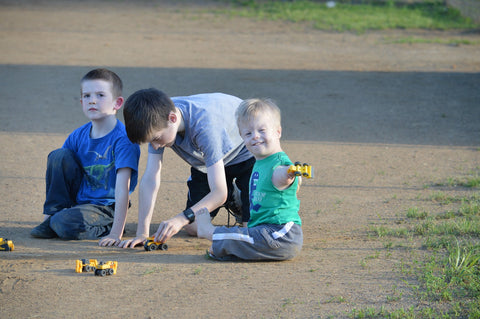 boy with limb differences plays outside with typical older brothers