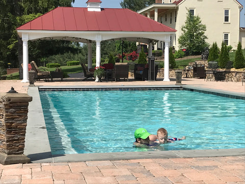 boy with limb differences swims in the pool with help from his mother