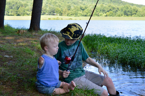 boy with limb differences goes fishing with older typical brother