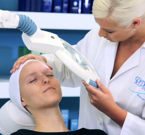 Repêchage Esthetician analyzes clients’ skin with magnifying lamp