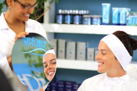 Repêchage Esthetician shows client the beautiful results of the facial in a mirror