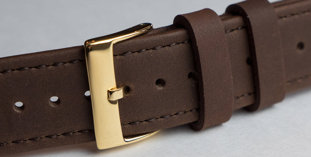 gold buckle on saddle leather